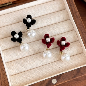 Elegant velvet flower earrings with pearls in red and black displayed in a wooden jewelry box