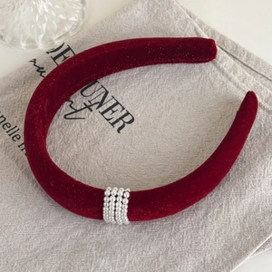 Close-up of deep red velvet headband featuring four rows of elegant white pearl decorations