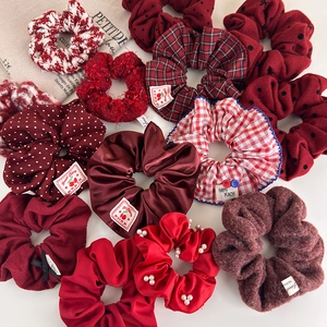 Red plush and satin scrunchie set with assorted textures and pearl embellishments