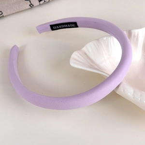 Detailed view of the handmade label and textured lavender fabric on the thick headband