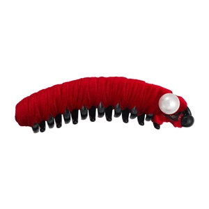 Close-up of a red pleated fabric hair clip with a white pearl and scalloped edges