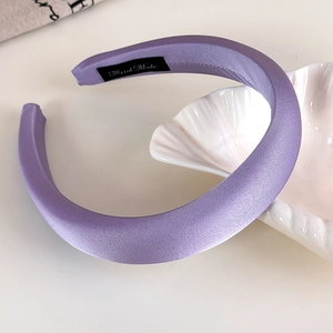 Detail of purple satin padded headband with handmade label on ceramic shell tray