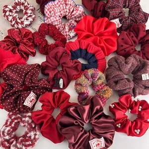 Set of festive red hair scrunchies in satin, tweed, and knit fabrics with pearl accents