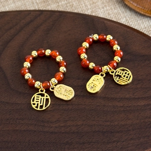 Détail de bagues élastiques en perles pour le Nouvel An chinois avec pendentifs Fu et Cai
