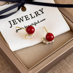 Detailed close-up of red agate earrings with fan-shaped mini pearls and gold plating