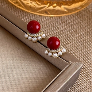 Elegant red bead stud earrings with gold fan-shaped pearl accents and crystals