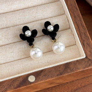 Detail showing vintage black velvet flower earrings with elegant white hanging pearls