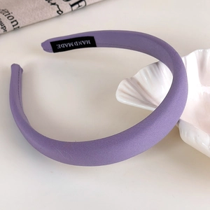 Close-up of handmade label on padded lavender headband with a woven fabric finish