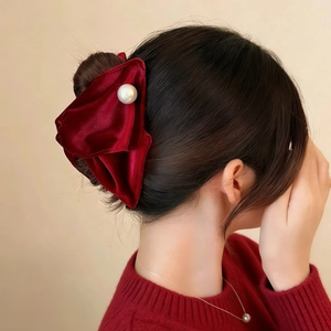 Elegant red velvet bow hairband with pearl accent for women shown on model