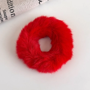 Detailed view of the soft faux fur texture on a festive bright red plush scrunchie