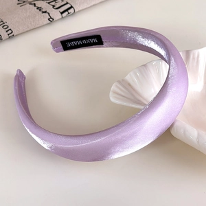 Detailed view of handmade light purple padded headband with glossy satin texture
