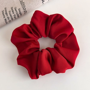 Detailed close-up of dark red scrunchie showing the soft matte plush texture and fabric folds