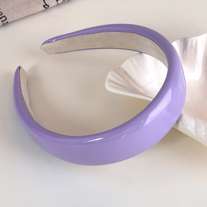 Detail view of purple padded headband showing glossy finish and non-slip inner fabric lining