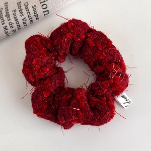 Detailed macro view of dark red knitted scrunchie with silver glitter thread and Korea label