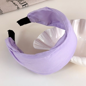 Detail view of lavender wide headband featuring pleated fabric and protective black end caps