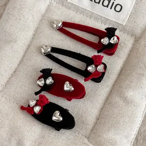 Detail view of red and black velvet hair clips with rhinestone hearts and bows