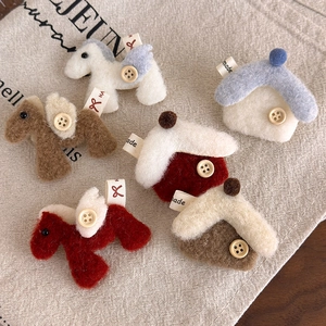 Macro detail of handmade felt horse brooches with wooden buttons and textile labels