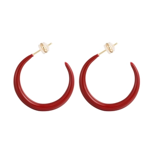 Detailed macro view of red enamel C-shaped hoop earrings with gold-plated metal accents