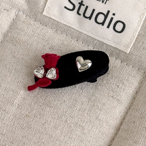 Detailed macro of vintage velvet hair clip with red ribbon and heart crystal accents