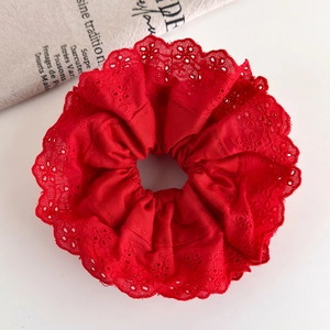 Detailed macro view of the festive red cotton scrunchie with floral embroidery edges