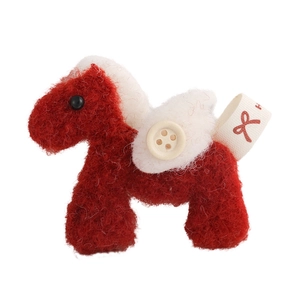 Detail of red felt horse brooch featuring white wings and yellow button accessory