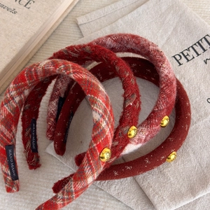 Retro red plaid tweed headband with golden butterfly button in a cozy setting