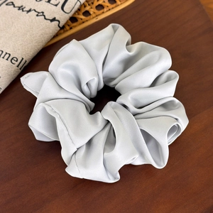 Detailed view of oversized satin silk hair scrunchie in elegant silver grey finish