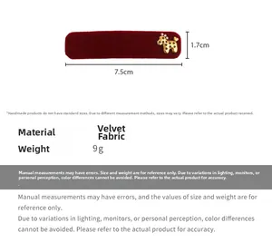 Detail view of a 7.5cm red velvet hair clip with a golden dog charm and star patterns