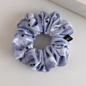 Macro detail of lavender velvet polka dot scrunchie with soft texture and stitching