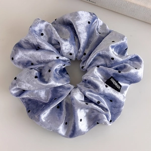 Detail of light purple velvet scrunchie with black polka dots and handmade label