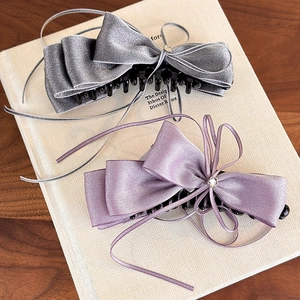 Vue détaillée des pinces à cheveux en satin argenté et violet avec rubans et strass