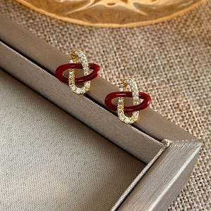 Elegant concentric knot stud earrings in gold and burgundy zircon for the Year of Snake