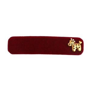 Red velvet hair clip with golden metal puppy ornament on a white background