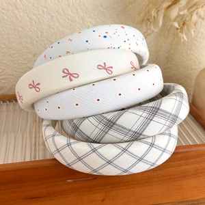 Détail de serre-têtes en tissu à motifs avec rembourrage sur un plateau en verre décoré