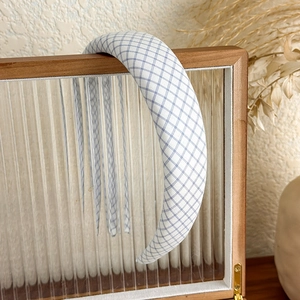 Detail of blue and white checkered padded headband on a wooden storage organizer box