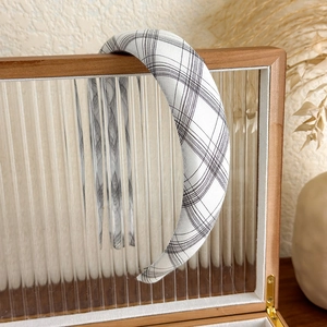 Détail d'un serre-tête rembourré à carreaux vintage sur une boîte décorative
