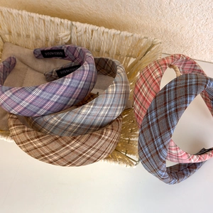 Detailed view of the handmade label and plaid fabric texture on wide padded headbands