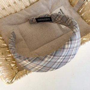Close-up of handmade plaid fabric headband featuring a vintage blue and red checkered pattern