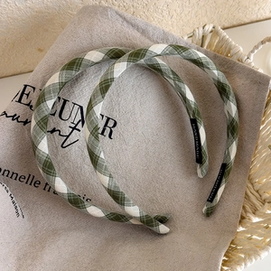 Green and white plaid headband set with handmade label on beige linen background