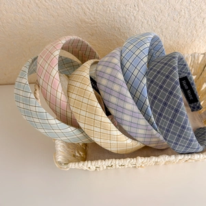 Détail de serre-têtes en tissu à carreaux colorés dans un panier avec étiquettes