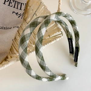 Detail of green plaid fabric headband with handmade label and woven texture details