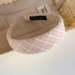 Détail du bandeau en tissu à carreaux roses avec étiquette artisanale faite à la main