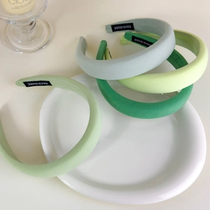 Detailed view of handmade thick sponge headbands in various shades of matte green fabric