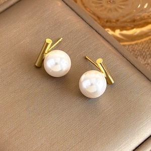 Close-up of minimalist pearl stud earrings with S925 silver needles and gold finish
