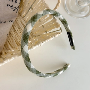 Detail showing the green and white plaid headband with a handmade textile label on the side