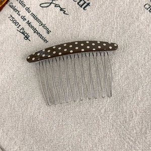 Detailed view of vintage polka dot acetate hair comb with fourteen durable metal teeth