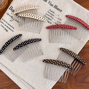 Vintage polka dot acetate hair combs in four colors on a textured linen background