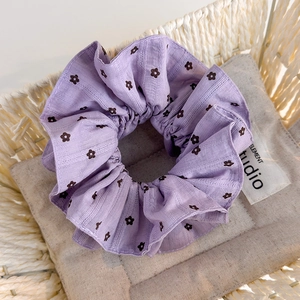 Détail d'un chouchou à fleurs violettes avec des textures fines et des plis doux