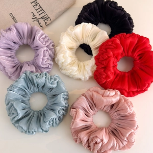 Flat lay of six large pleated organza scrunchies in assorted colors with pearl luster finish