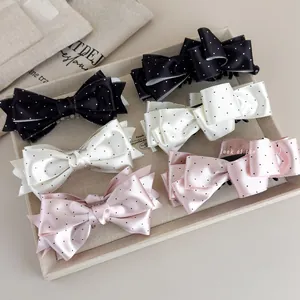 Set dettagliato di tre fermagli per capelli in raso a pois nero bianco e rosa